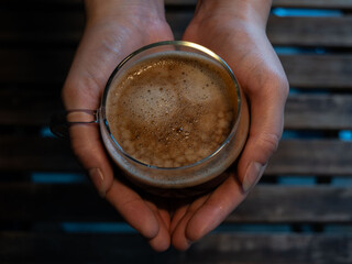 Hands Holding a Glass Cup of Fresh Frothy Coffee – Warm Morning Drink and Cozy Lifestyle Concept