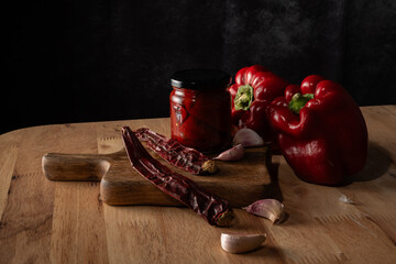 Red peppers, dried chili, and garlic cloves preparing a preserve