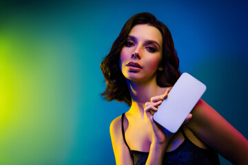 Fashionable young woman posing with elegance, showcasing modern style under vibrant neon lights in club atmosphere