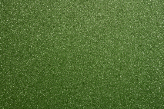 Bright green textured surface with fine glitter particles, ideal for creative projects or background design use