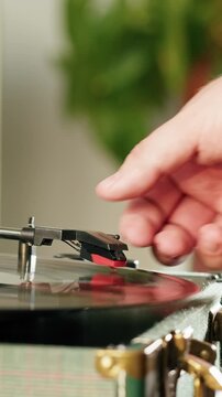 Retro Vinyl record player playing music, close-up macro shot of vintage LP disc old phonograph spinning. Retro music player at home.