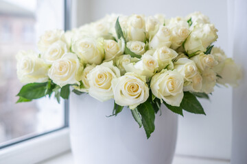 White roses arranged beautifully in a decorative vase, creating an elegant background for celebrations, anniversaries, and special occasions with a touch of floral charm