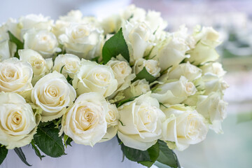 White roses arranged beautifully for a celebration, showcasing delicate petals and lush greenery, perfect for anniversaries or romantic occasions with copy space