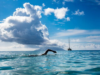 Fototapeta premium Open Water Swimming with Sailboat and Dramatic Cloudscape