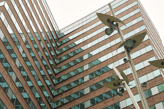  Element of a modern high-rise building with a glass facade and a lantern in the foreground. Modern European architecture