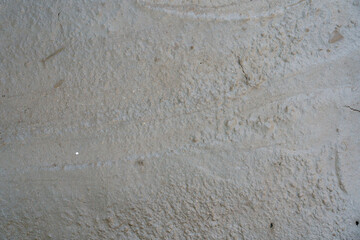 Surface of wet concrete showing texture and patterns from footprints and other marks