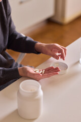 Medicinal moment captured, Calm scene depicting nighttime wellness with pills and water, Gentle indoor setting featuring hands managing pills during peaceful evening routine