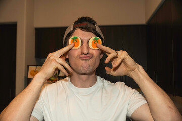 youthful energy with fruit humor, spontaneous snapshot depicting man having fun with fruit slices indoors