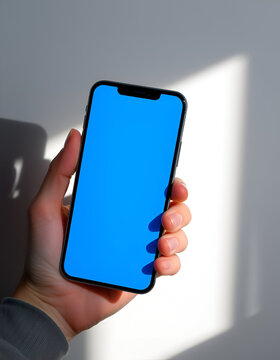 Hand holding modern smartphone with empty screen. Mobile phone mockup for app developers and designers. Ideal for showcasing digital products and mobile applications.
