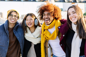 Diverse group of gen z happy friends having fun together on winter vacation. Multicultural teenage...