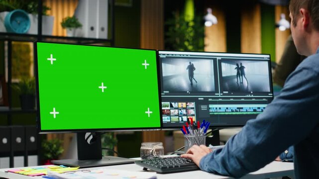 Green screen with skilled male video editor working with software in creative office, editing video footage and color grading for the post production process modern content. Camera B.