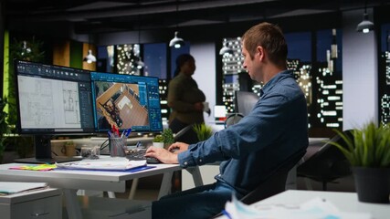 Portrait of male specialist in office uses CAD software and blueprints plan, designing house interior with user interface for virtual home customization. Detailed architectural layout. Camera A.