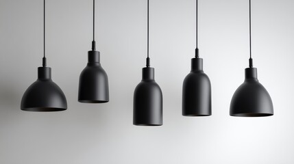 Modern black pendant lights hang in a row against a simple gray wall for a stylish look in interior design
