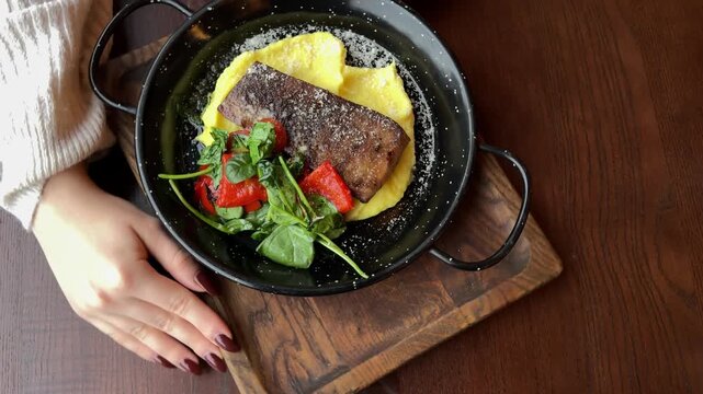Ossobuco with polenta. Top view with smoke. Beef tongue with mashed potatoes and grilled vegetables served on black iron plate