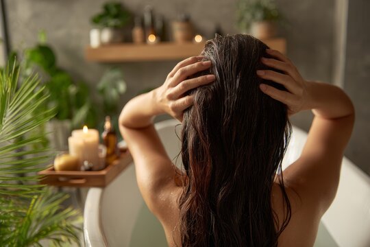 Relaxing in a luxurious bathtub surrounded by candles and greenery for a soothing self-care experience