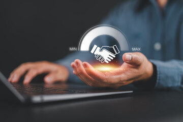 Business partnership and collaboration concept. Businessman holding a handshake icon and a progress bar from minimum to maximum, symbolizing teamwork, trust, negotiation, and corporate success.