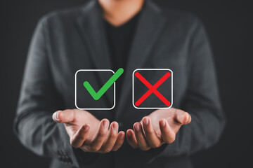 Businessman holding check mark and cross icons, representing decision making, approval, rejection, evaluation, and business management concept. Yes or no concept.