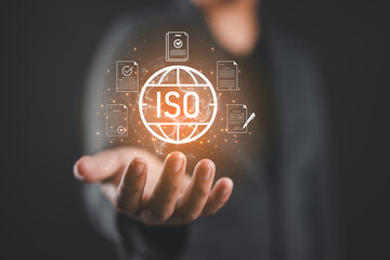 Businessman holding ISO certification icon with digital documents, representing international standards, quality assurance, compliance, corporate management for global business success. ISO quality