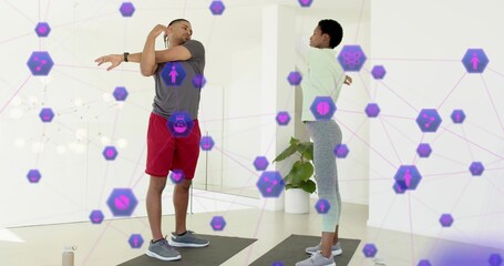 Naklejka premium Stretching exercise partners extending arms on mats at home in sportswear with purple AR icons