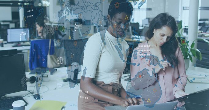 Reviewing two women in business casual leaning over laptop and tablet at office, AR overlay