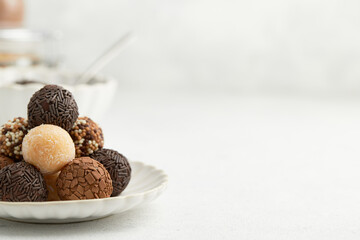 Typical Brazilian sweet brigadeiro. A heap of assorted flavors of candies on a white table