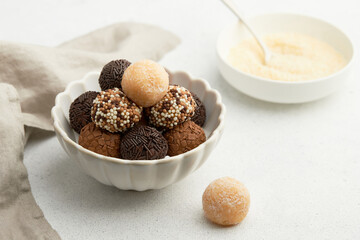 Typical Brazilian sweet brigadeiro. A heap of assorted flavors of candies on a white table