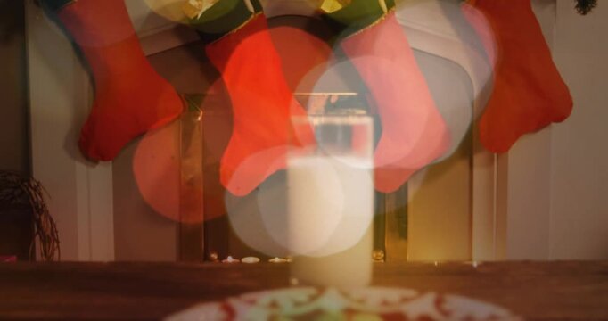 Camera panning downward revealing cookies and milk, bokeh shifting, composing cozy holiday scene