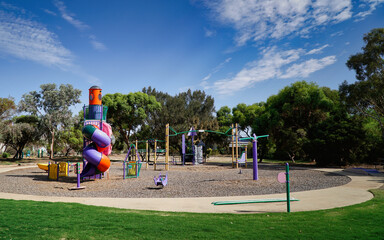 Colorful playground equipment in a sunny park with spiral slide and climbing structure