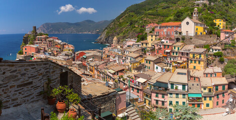Cliffside view of Vernazza with coastal buildings and sea in Liguria, Italy