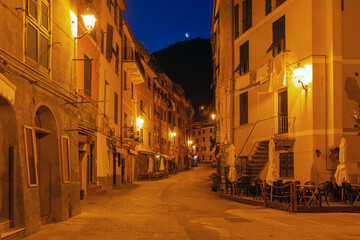 Quiet narrow street in Vernazza at night with warm lights in Liguria, Italy