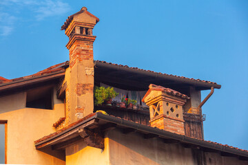 Close-up of traditional brick chimneys with roof tiles in Bergamo, Lombardy, Italy