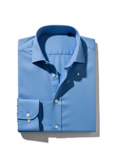 A neatly folded light blue long-sleeved dress shirt with white buttons and a classic collar lies on a white surface casting a shadow