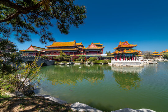 Swans in front of traditional red Chinese pavilion in San xian shan area of Penglai, China