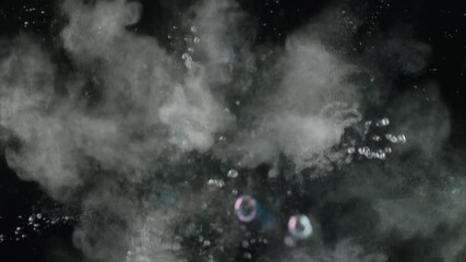 Abstract macro shot of a dust explosion in water, creating a cloud of white particles and bubbles against a dark background. - Powered by Adobe