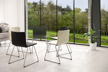 Chairs in circle in room with large window. Psychotherapy session