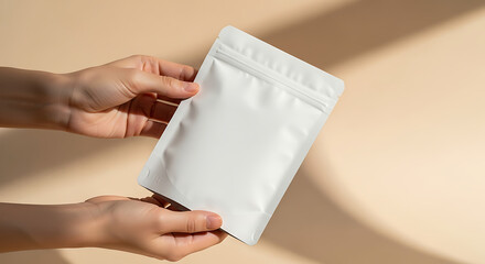 A person holds a blank white doypack pouch for product branding template with modern minimalist shadows on a neutral background