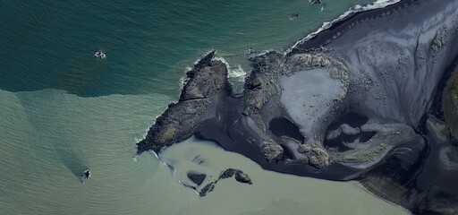 Obraz premium Volcanic Headland Meets Water Aerial View Iceland Contrast