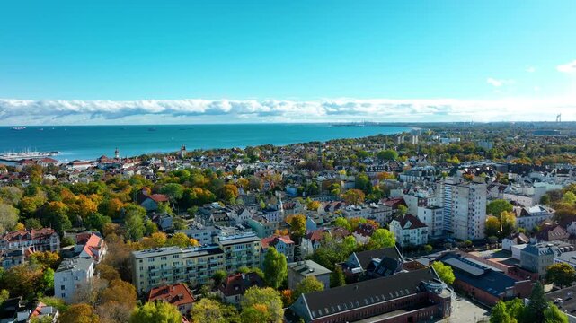 Drone panorama of Sopot city center with colorful rooftops, trees, and Baltic Sea coastline
