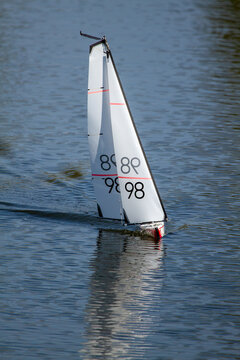 Remote controlled yacht sailing on a suburban lake.