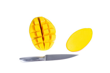 Halved mango with sliced half and silver knife on transparent background