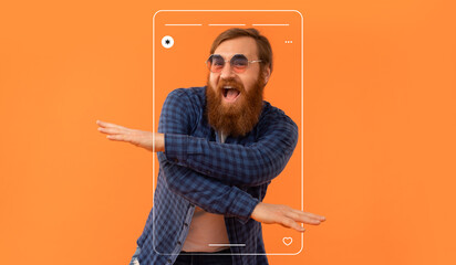A lively man is dancing joyfully in front of a bright orange backdrop. He sports a beard and wears sunglasses. His playful posture captures a fun moment, creating a vibrant and energetic scene.