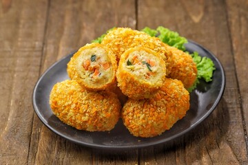 Kroket kentang. Croquettes are lumps of finely mashed potatoes filled with seasoned minced meat and mixed with vegetables such as carrots or green beans. The croquettes are coated with beaten egg and 