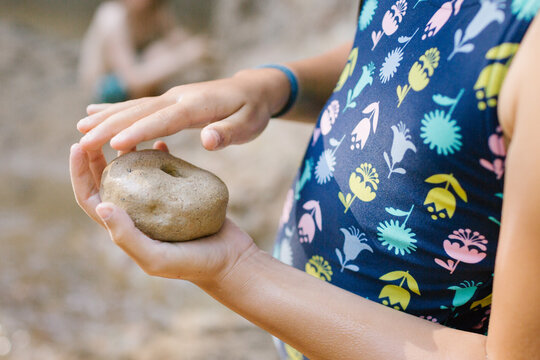 Child holding stone with hole