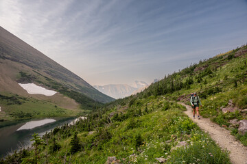Backpacker Passing Ptarmigan Lake In Glacier