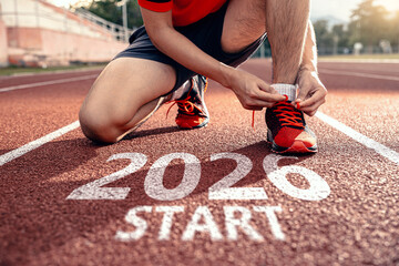 Hands of man tying laces running shoes prepares for 2026 goals.