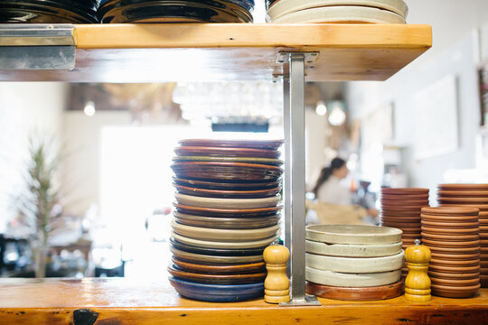 Stacks of plates and dishes on shelf in cafe