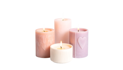 Four lit cylindrical candles in pink, lavender, and white, some with heart designs, on clean white background
