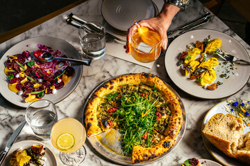 Restaurant Action Scene with Pizza, Pasta, Hands with Jewelry and cocktails