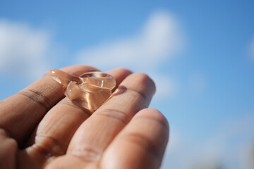 Hand holding aloe vera gel against blue sky