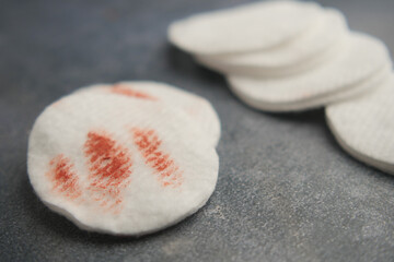 Cotton pads with makeup smudges on a dark surface